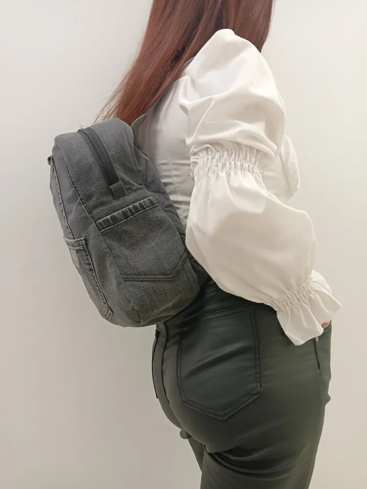 Casual unisex denim backpack made from recycled jeans, with 3 pockets outside and 3 pockets inside (1 with a zipper), strong 2-color strap on adjustable straps. Inside is colored synthetic fabric. The back wall is quilted.