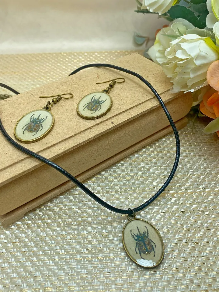 A set of jewelry with the image of beetles. Individual design.