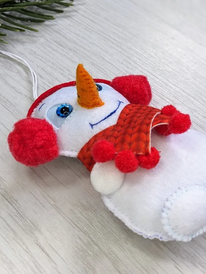 Cute felt snowman. Snowman with blue eyes and red scarf