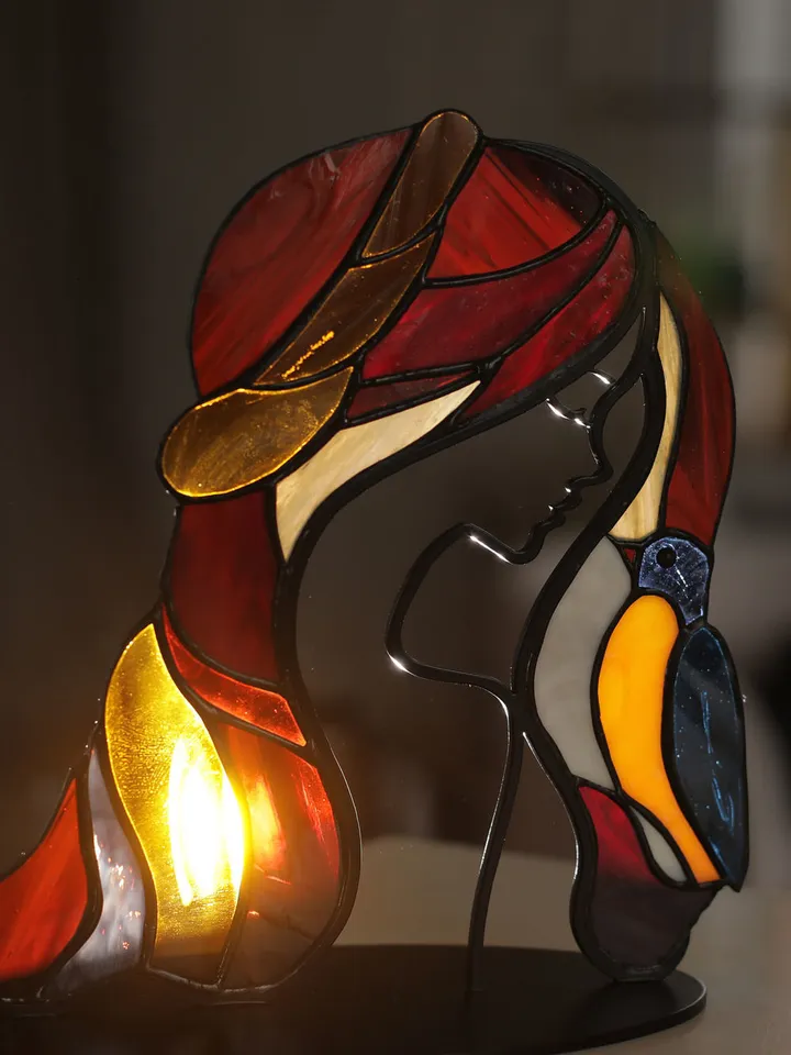 Girl with a Bird. Tiffany Stained Glass, Stained Glass Featuring a Girl and a Bird, Stained Glass with a Girl and Bird on a Stand, Stained Glass "Girl and Bird" on Base, Stained Glass Featuring a Girl and Bird