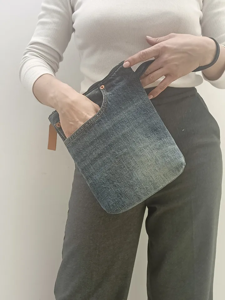 A small denim clutch bag , recycled jeans purse, closes with a zipper, 3 functional jeans pockets on the outside, cotton and 2 pockets on the inside.