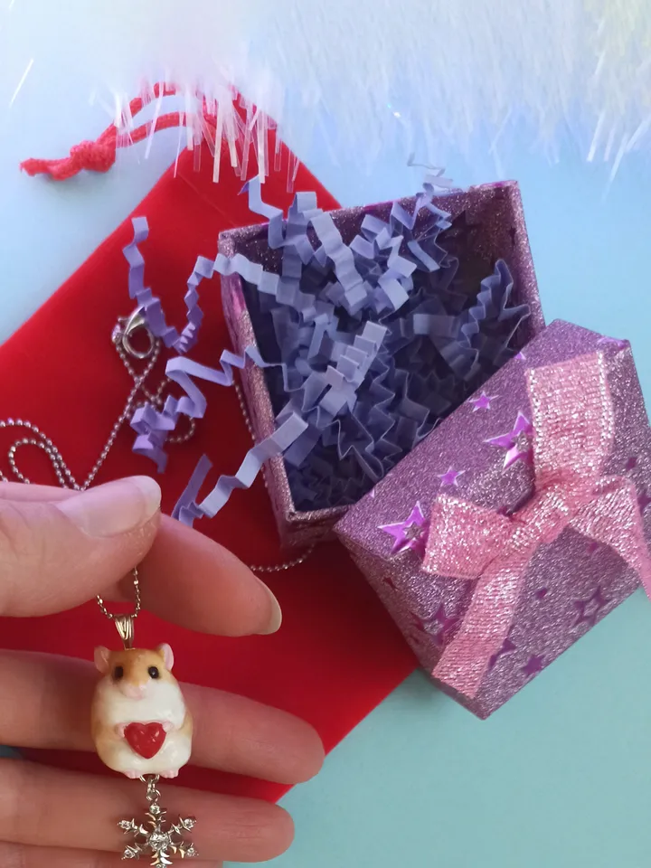 A small handmade hamster necklace in red and white color
