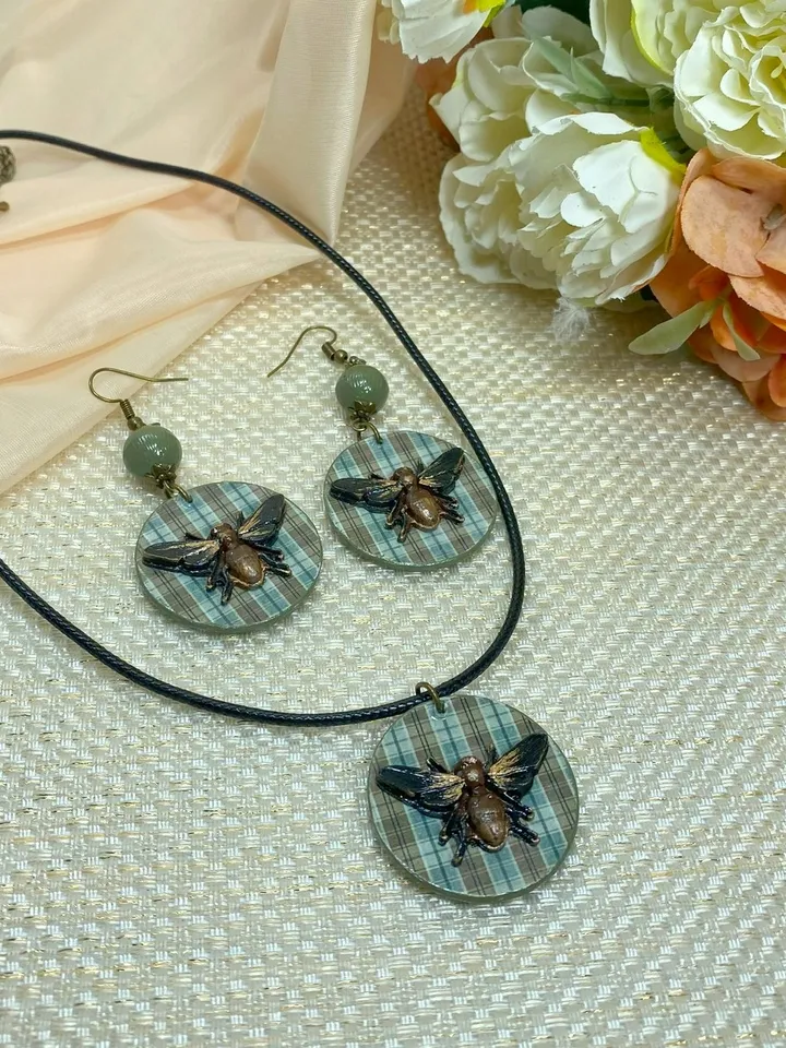 Author's set of handmade jewelry.Earrings and pendant on a cord with voluminous flies.