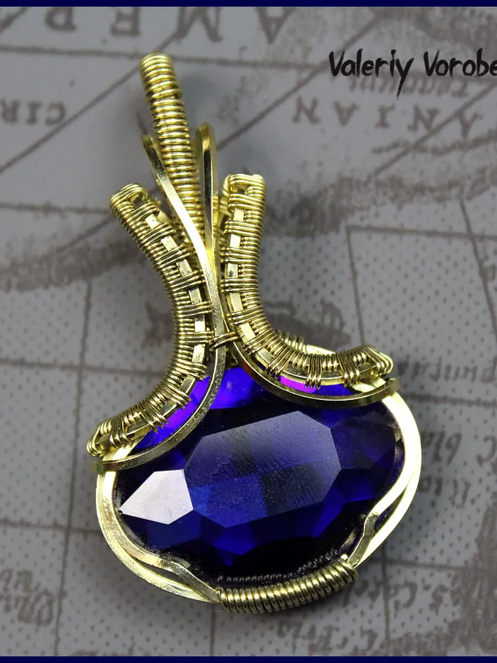 Handmade pendant made of brass wire and cut glass.