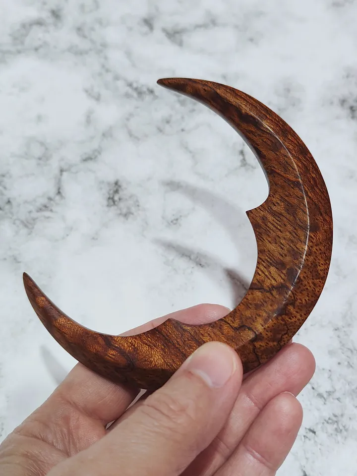 Hair bun pin in the shape of a moon.