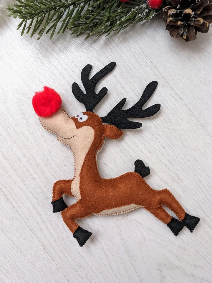 Funny reindeer from Santa's sleigh. Brown felt Deer with a red nose. Christmas gift.