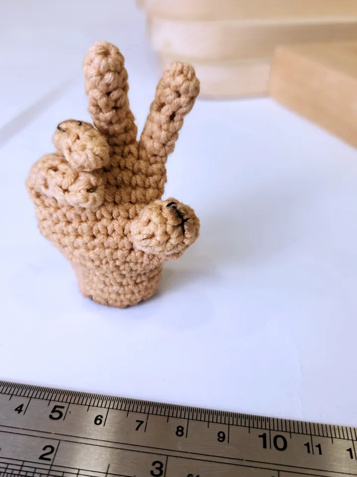 Thing crochet pattern from Wednesday -Photo tutorial of small hand from Wednesday with a heart