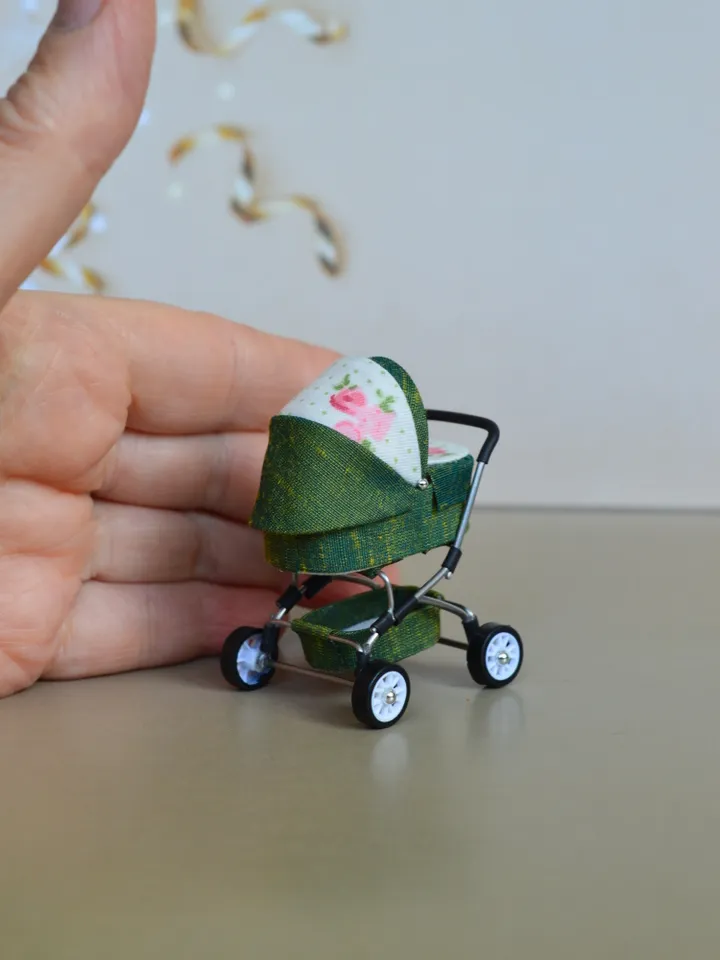 Miniature toy doll stroller in 1/24 scale. Complete with baby doll.