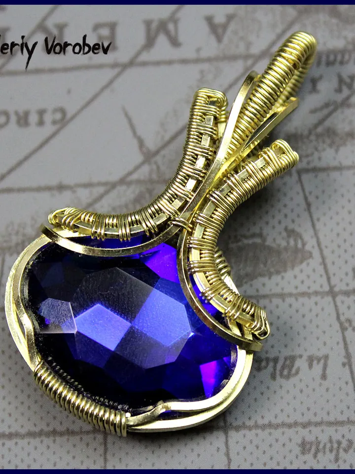 Handmade pendant made of brass wire and cut glass.