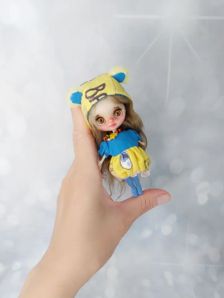 Cute Petite Blythe doll in a teddy bear outfit. Doll with blond hair and green eyes.