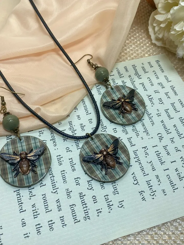 Author's set of handmade jewelry.Earrings and pendant on a cord with voluminous flies.