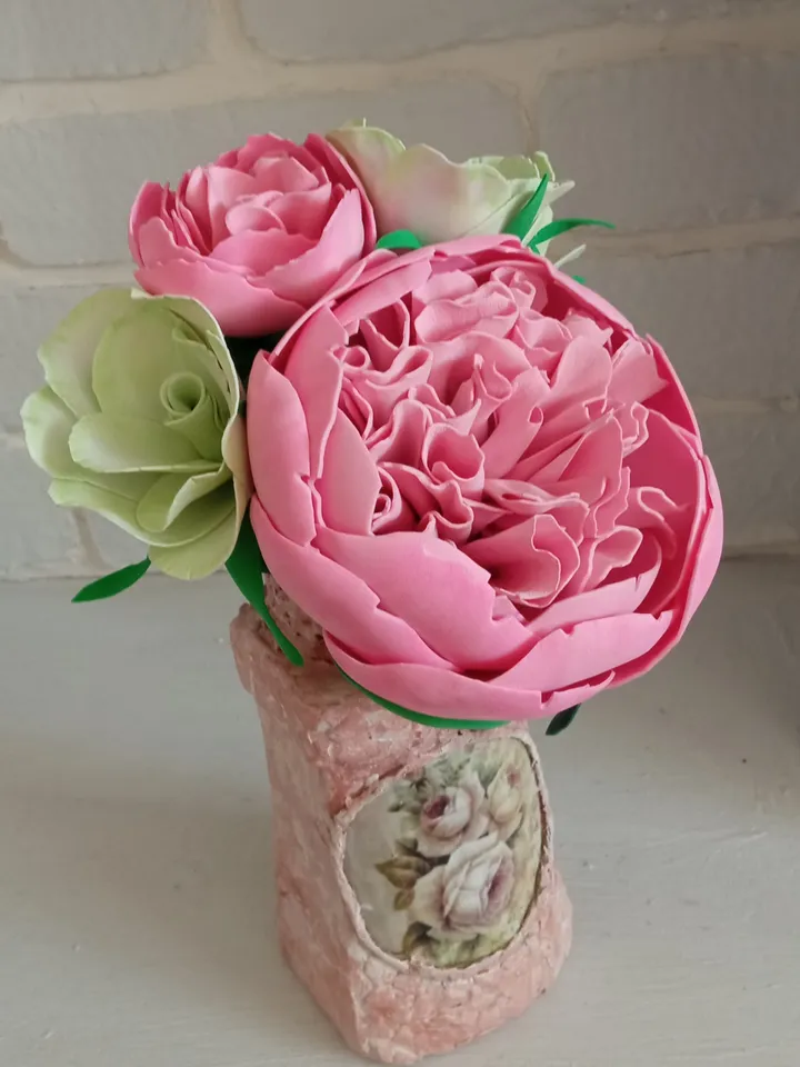 Delicate composition of pink peonies and eustomes in a handmade vases