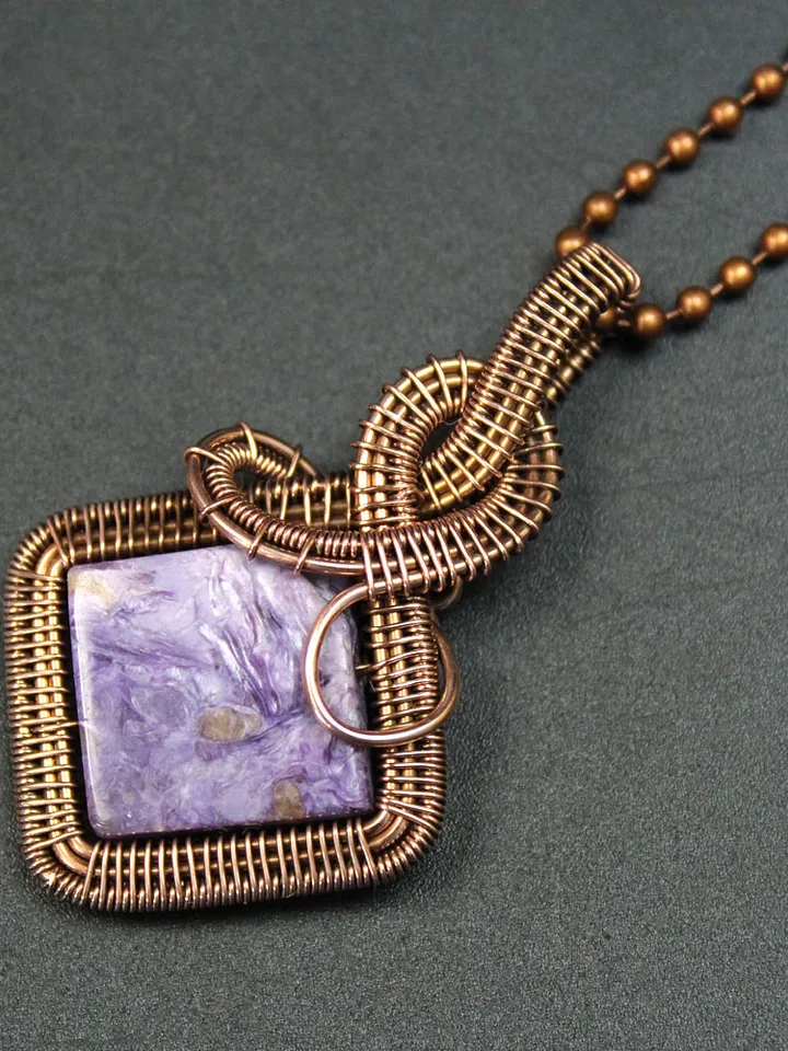 Handmade pendant of natural charoite and copper wire.