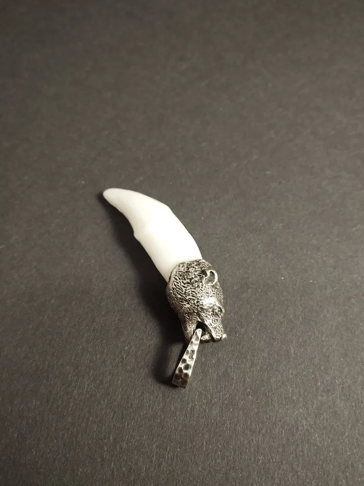 A silver-framed wolverine's fang.