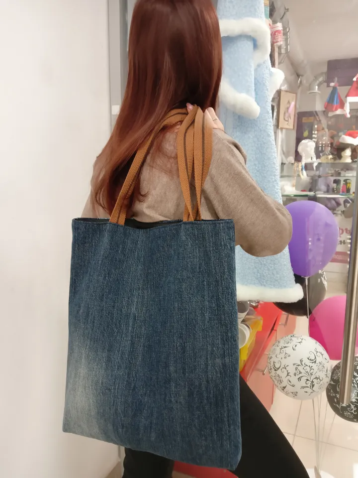 Large denim shopper, shopping bag, city bag, made from recycled jeans, with comfortable handles 60 cm long. Comfortable to wear on the shoulder. Bag with lining made of black synthetic fabric, 2 pockets and strong handles made of 2-color straps. The front
