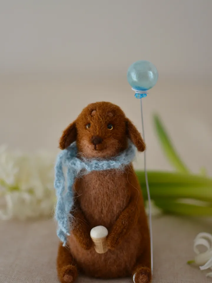 Handmade toy. Dachshund puppy in a scarf, with ice cream and a ball