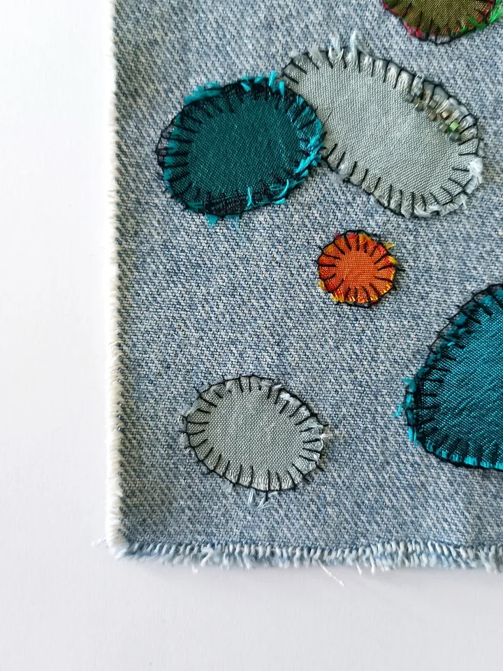 Upcycled denim/silk boro patch – visible mending.