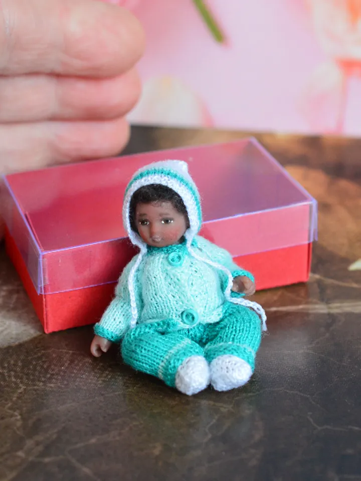 Miniature doll child in 12th scales. A baby for the dollhouse. Baby in a blue suit.