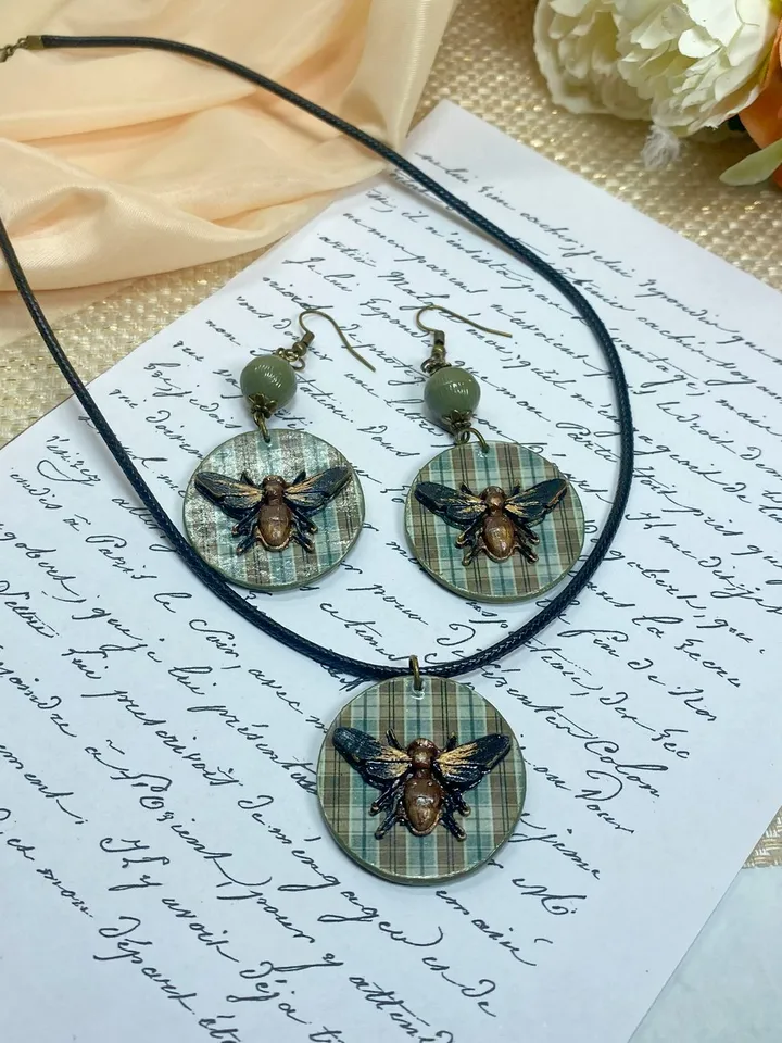 Author's set of handmade jewelry.Earrings and pendant on a cord with voluminous flies.