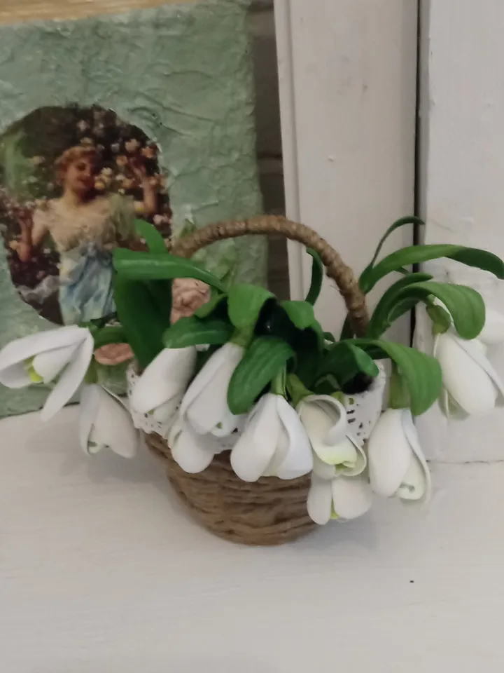 A bouquet of delicate handmade snowdrops in a basket