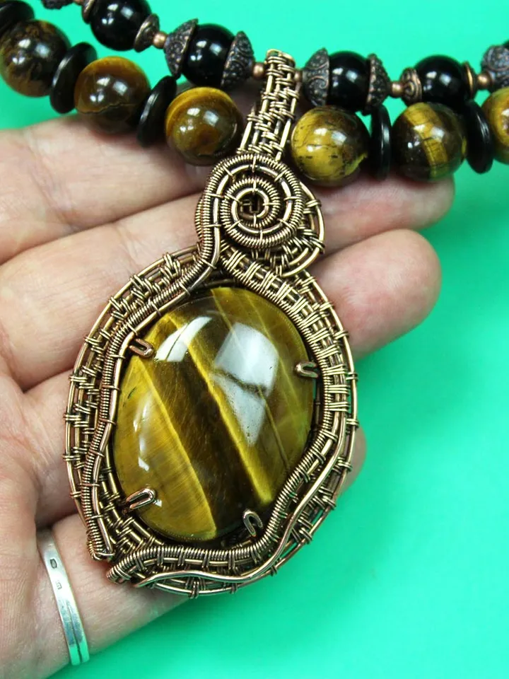 Handmade pendant made of Tiger Eye stone and copper wire.