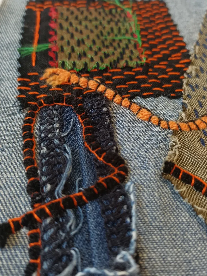 Upcycled denim boro patch with sashiko stitching – visible mending.