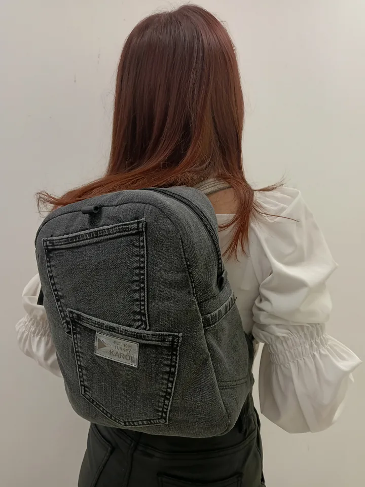 Casual unisex denim backpack made from recycled jeans, with 3 pockets outside and 3 pockets inside (1 with a zipper), strong 2-color strap on adjustable straps. Inside is colored synthetic fabric. The back wall is quilted.