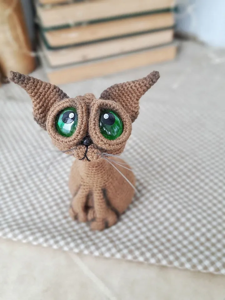 Crochet sculpture of a graceful brown cat with green eyes. Big-eyed cat as a gift for cat lovers.