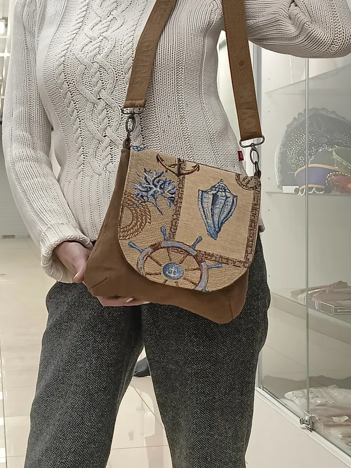 Denim handbag features a marine-style tapestry flap, cotton lining and 4 pockets inside. The strap on the carabiners is adjustable up to 123 cm /48,4". The size of the handbag is approximately 26cm/10,2"*23 cm/9", magnetic button closure. The weight is