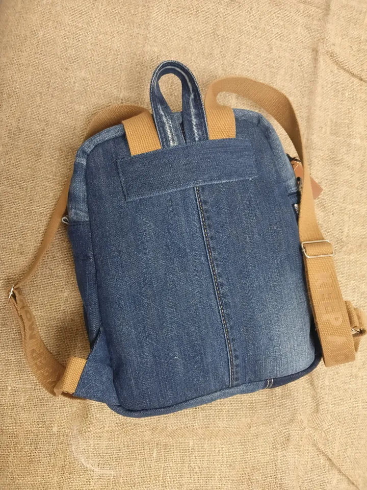 Casual unisex denim backpack made from eco-frendly recycled jeans, with 6 pockets outside and 2 pockets inside (1 with a zipper), strong belt on adjustable straps. Inside is colored cotton fabric. The back wall is quilted.