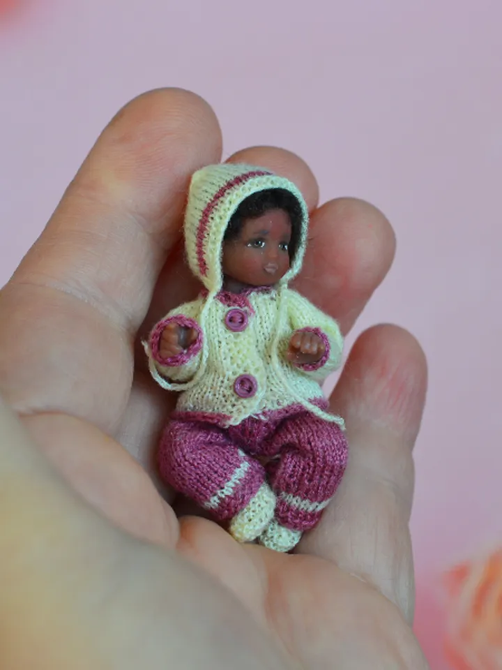 Miniature doll child in 12th scales. A baby for the dollhouse. Baby in a knitted suit.