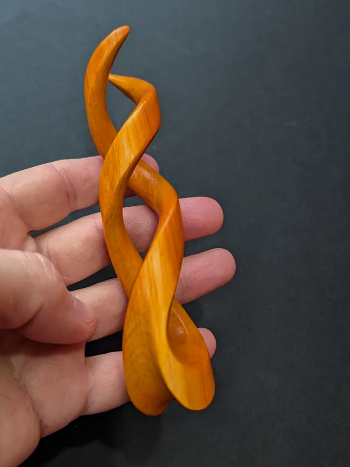 Spiral clip made of stabilized hornbeam orange. Twisted wooden hair fork.
