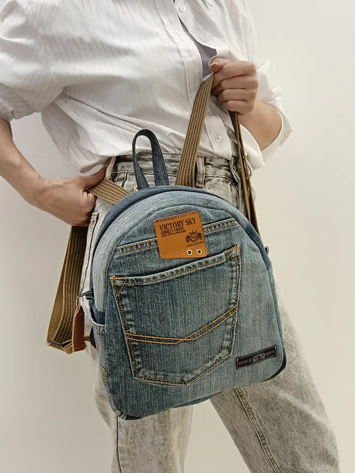 medium sized denim backpack made from recycled jeans for walking, studying, work, traveling. Backpack with 2 pockets outside and 3 pockets inside (1 with a zipper). Inside lining made of 100% cotton. Decorated with a label and a leather strip on the zippe