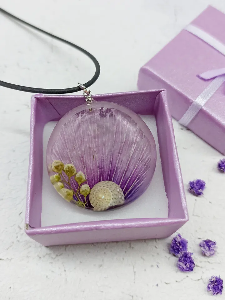 Round charm necklace with a lavender-pink malva petal, sorrel flowers and a snail shell Resin pendant with flowers