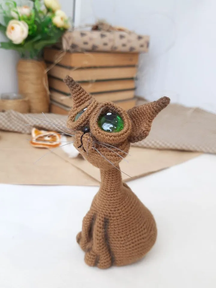 Crochet sculpture of a graceful brown cat with green eyes. Big-eyed cat as a gift for cat lovers.