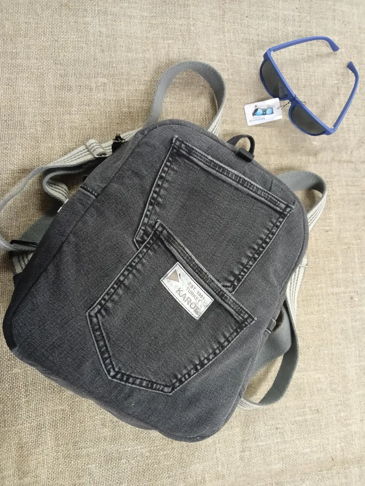 Casual unisex denim backpack made from recycled jeans, with 3 pockets outside and 3 pockets inside (1 with a zipper), strong 2-color strap on adjustable straps. Inside is colored synthetic fabric. The back wall is quilted.