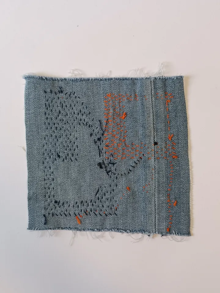 Upcycled denim boro patch with sashiko stitching – visible mending.