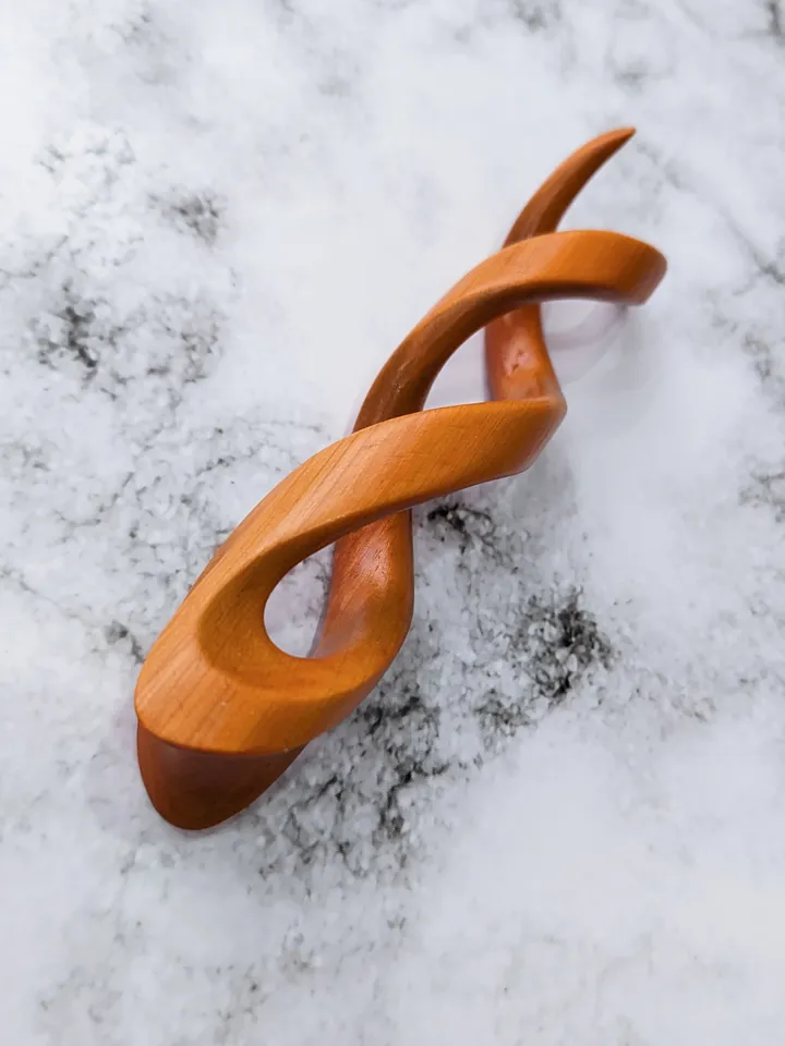 Spiral clip made of stabilized hornbeam orange. Twisted wooden hair fork.