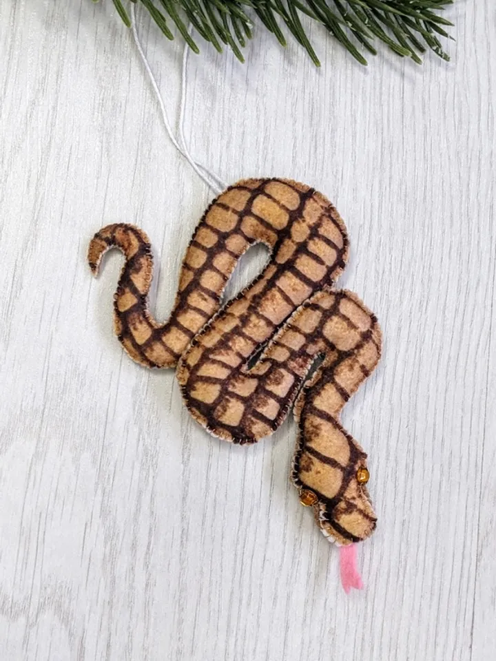 A reticulated brown snake is a symbol of the new year 2025 according to the eastern calendar. Christmas gift felt snake.