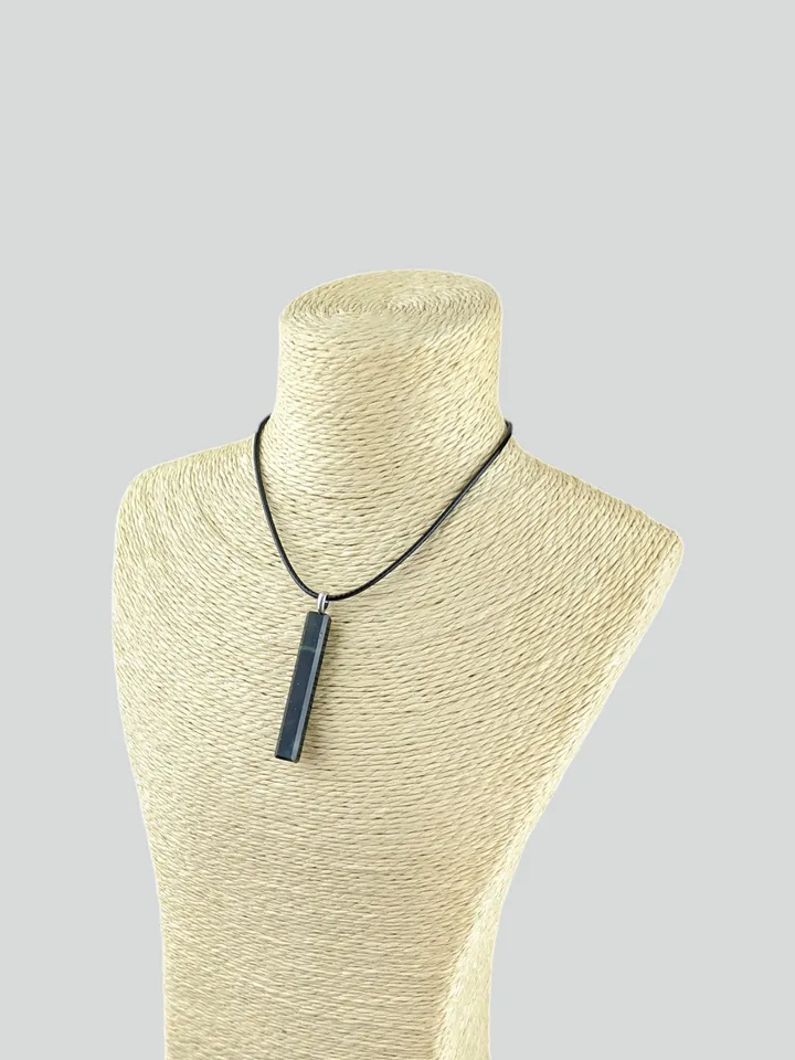Rectangular pendant made of dark green jade in the shape of a column.