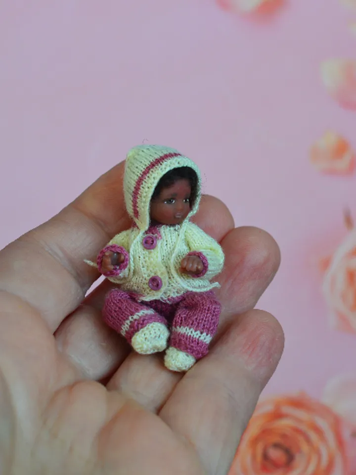 Miniature doll child in 12th scales. A baby for the dollhouse. Baby in a knitted suit.