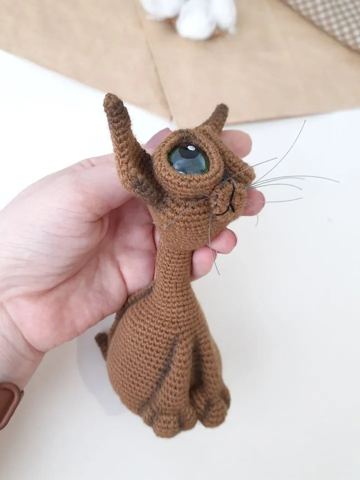 Crochet sculpture of a graceful brown cat with green eyes. Big-eyed cat as a gift for cat lovers.