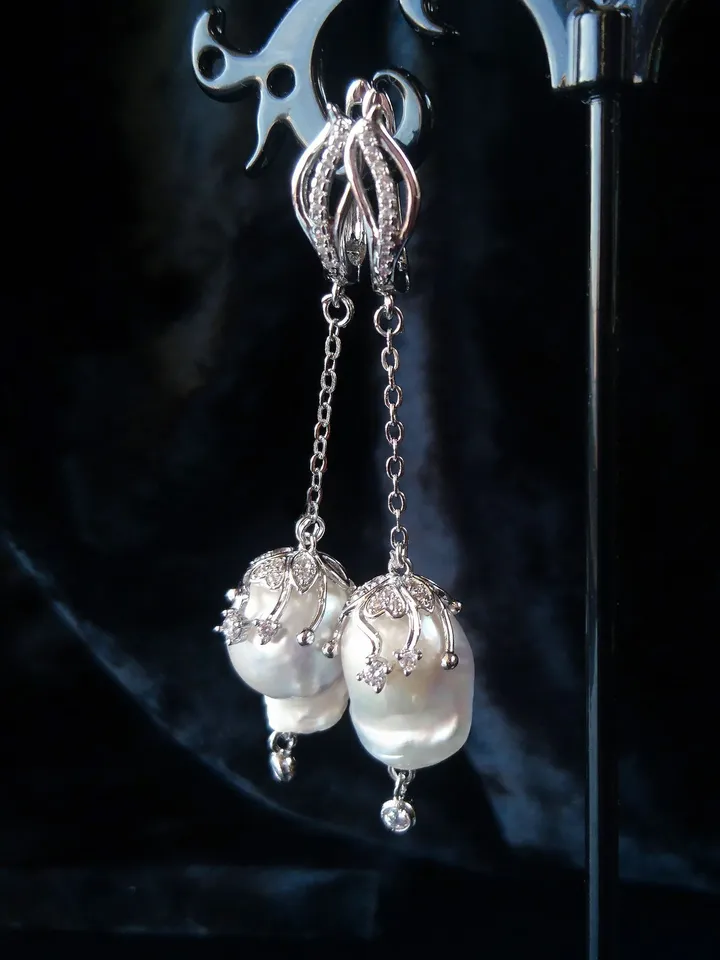 Earrings with baroque pearls and circus pendants on chains