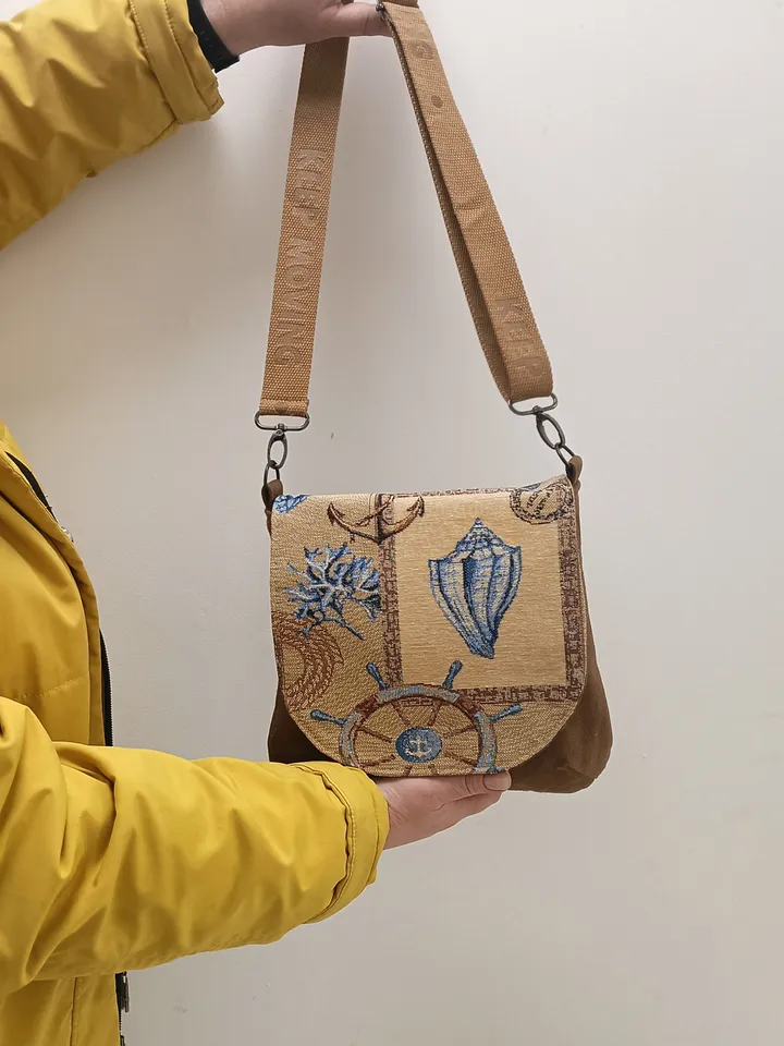 Denim handbag features a marine-style tapestry flap, cotton lining and 4 pockets inside. The strap on the carabiners is adjustable up to 123 cm /48,4". The size of the handbag is approximately 26cm/10,2"*23 cm/9", magnetic button closure. The weight is
