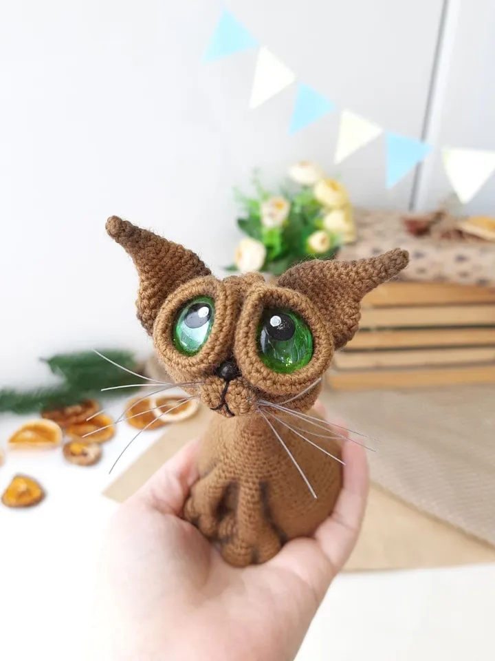 Crochet sculpture of a graceful brown cat with green eyes. Big-eyed cat as a gift for cat lovers.
