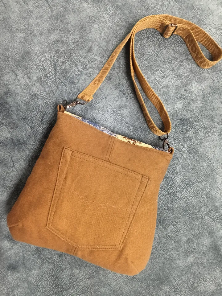 Denim handbag features a marine-style tapestry flap, cotton lining and 4 pockets inside. The strap on the carabiners is adjustable up to 123 cm /48,4". The size of the handbag is approximately 26cm/10,2"*23 cm/9", magnetic button closure. The weight is