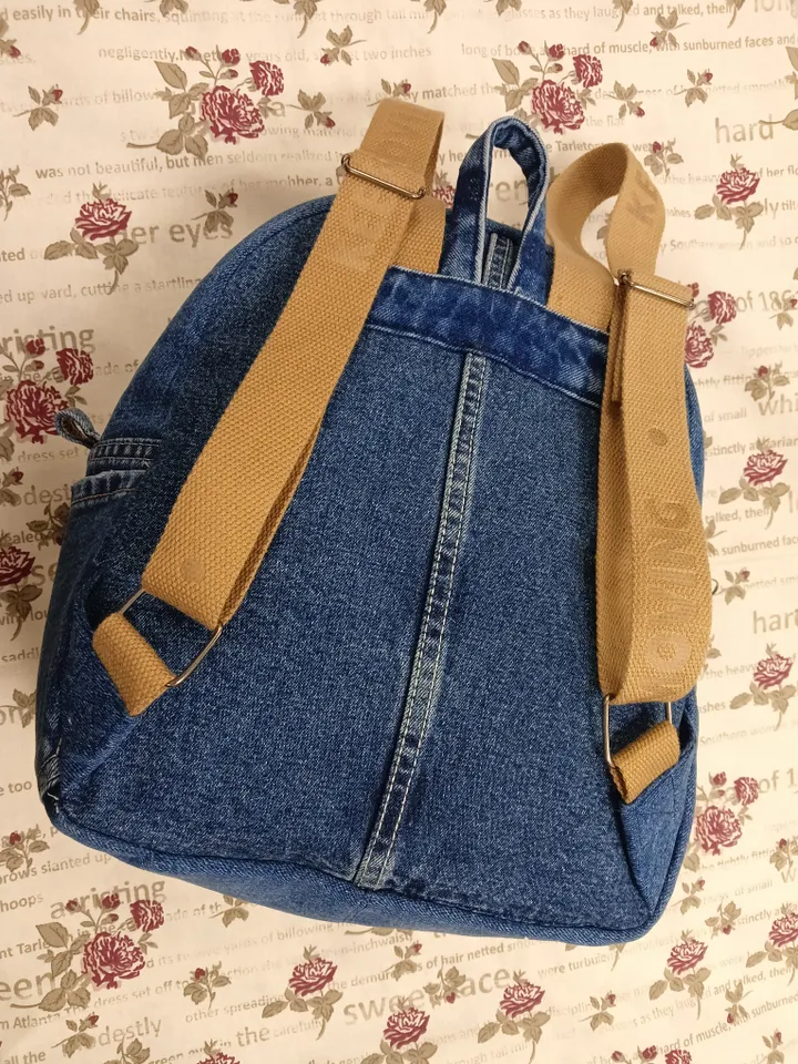 Everyday denim backpack made from recycled jeans, 3 pockets outside (1 volumetric with a zipper), 2 pockets inside (1 with a zipper) 100 percent cotton inside, strong handles made of cotton straps, leather strips on the zipper puller. decorated with a lab
