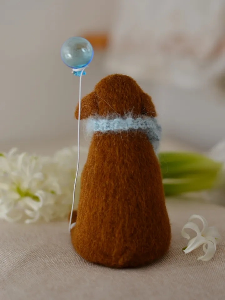 Handmade toy. Dachshund puppy in a scarf, with ice cream and a ball