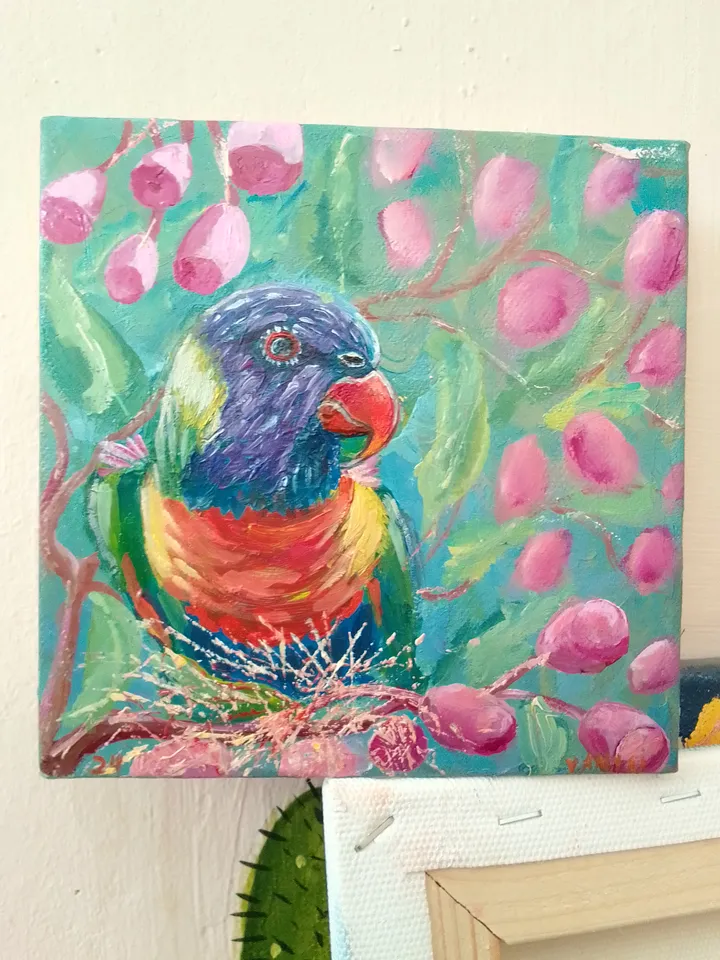 Parrot sits on a branch of a flowering tree