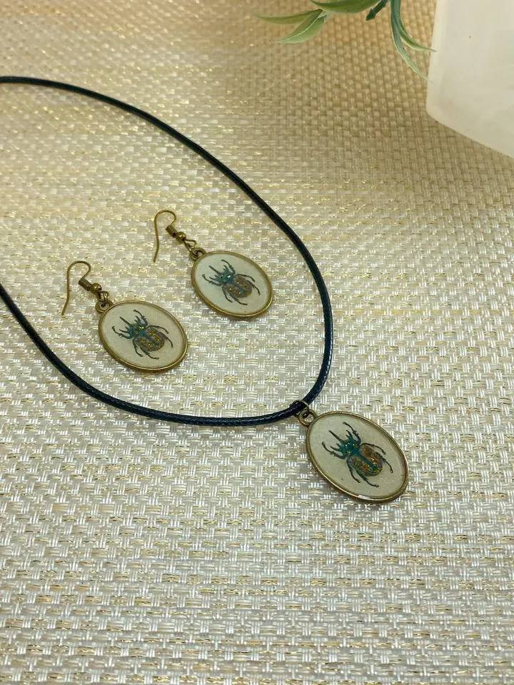 A set of jewelry with the image of beetles. Individual design.